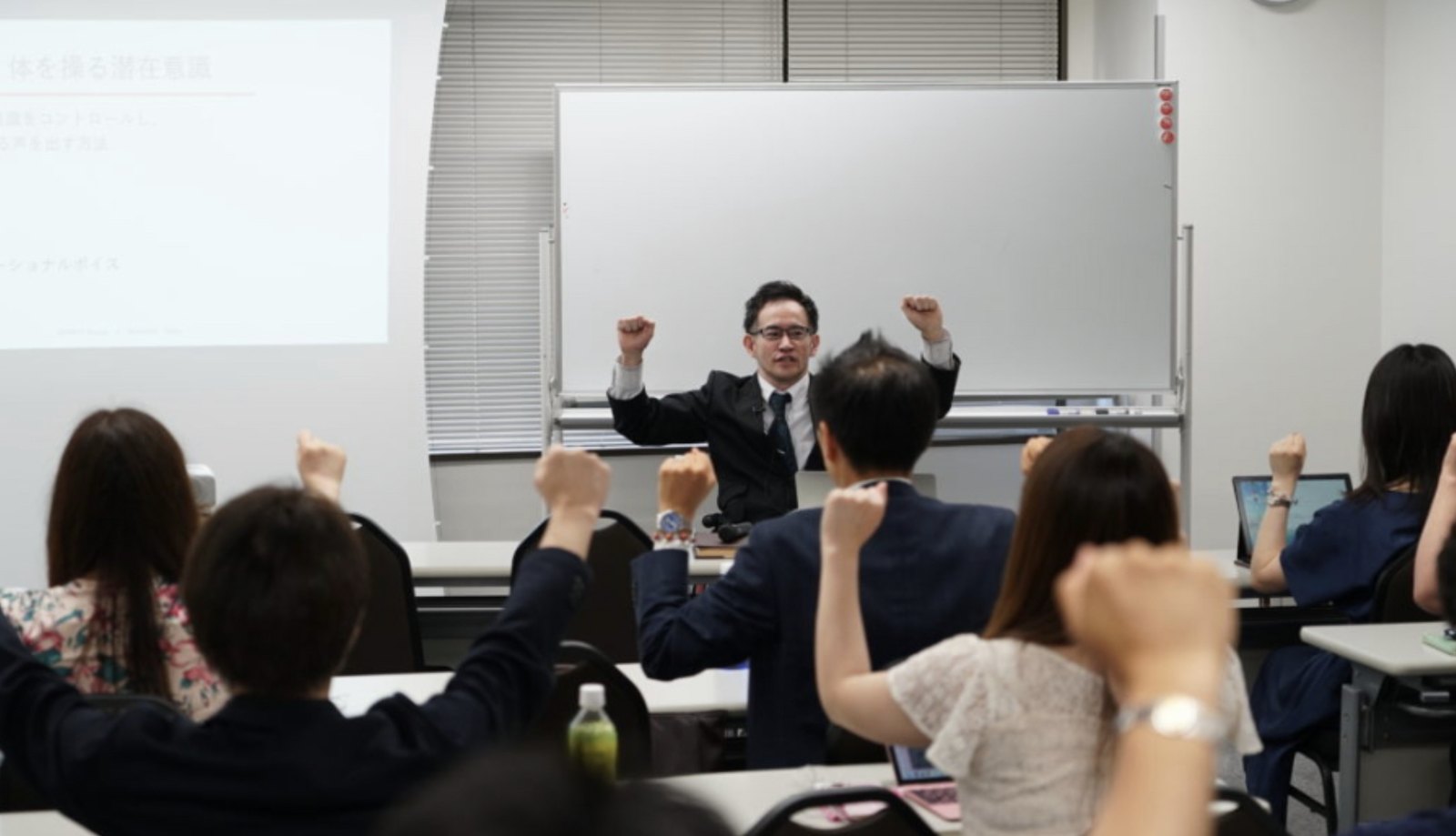 セミナーで受講者と一緒に拳を上げる齋藤信広